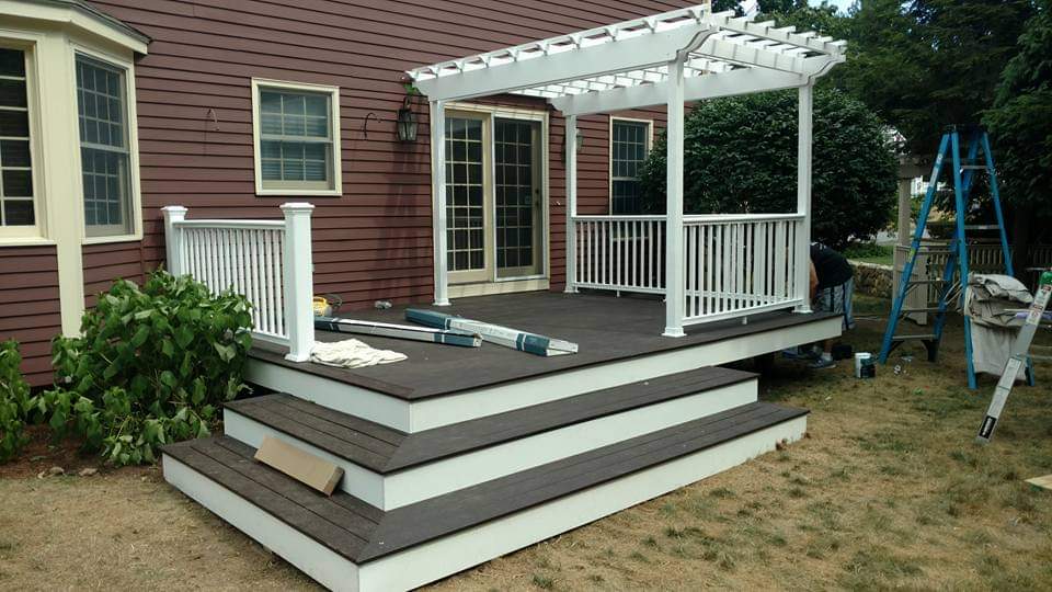After — composite deck with white pergola and stairs by Prairie Building Sutton, MA