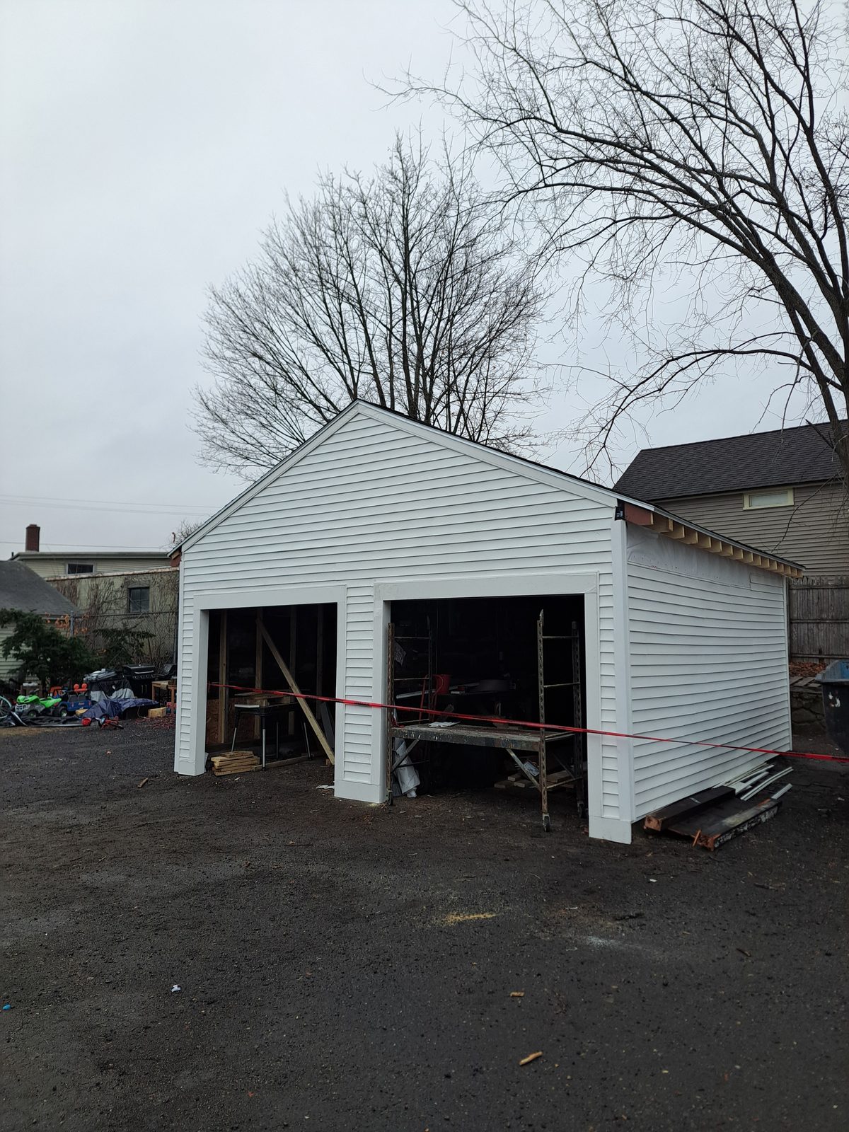 After — new white siding on a two-car garage in Sutton, MA