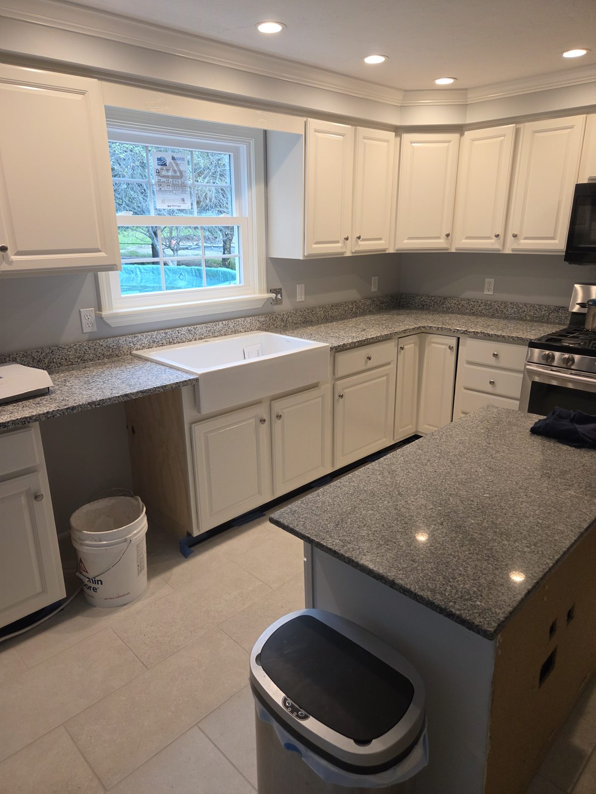 After — white cabinets, granite counters, and a farmhouse sink in a Sutton, MA kitchen