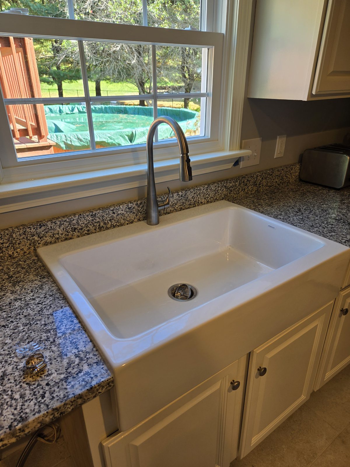 After — farmhouse sink and faucet under a kitchen window in Sutton, MA