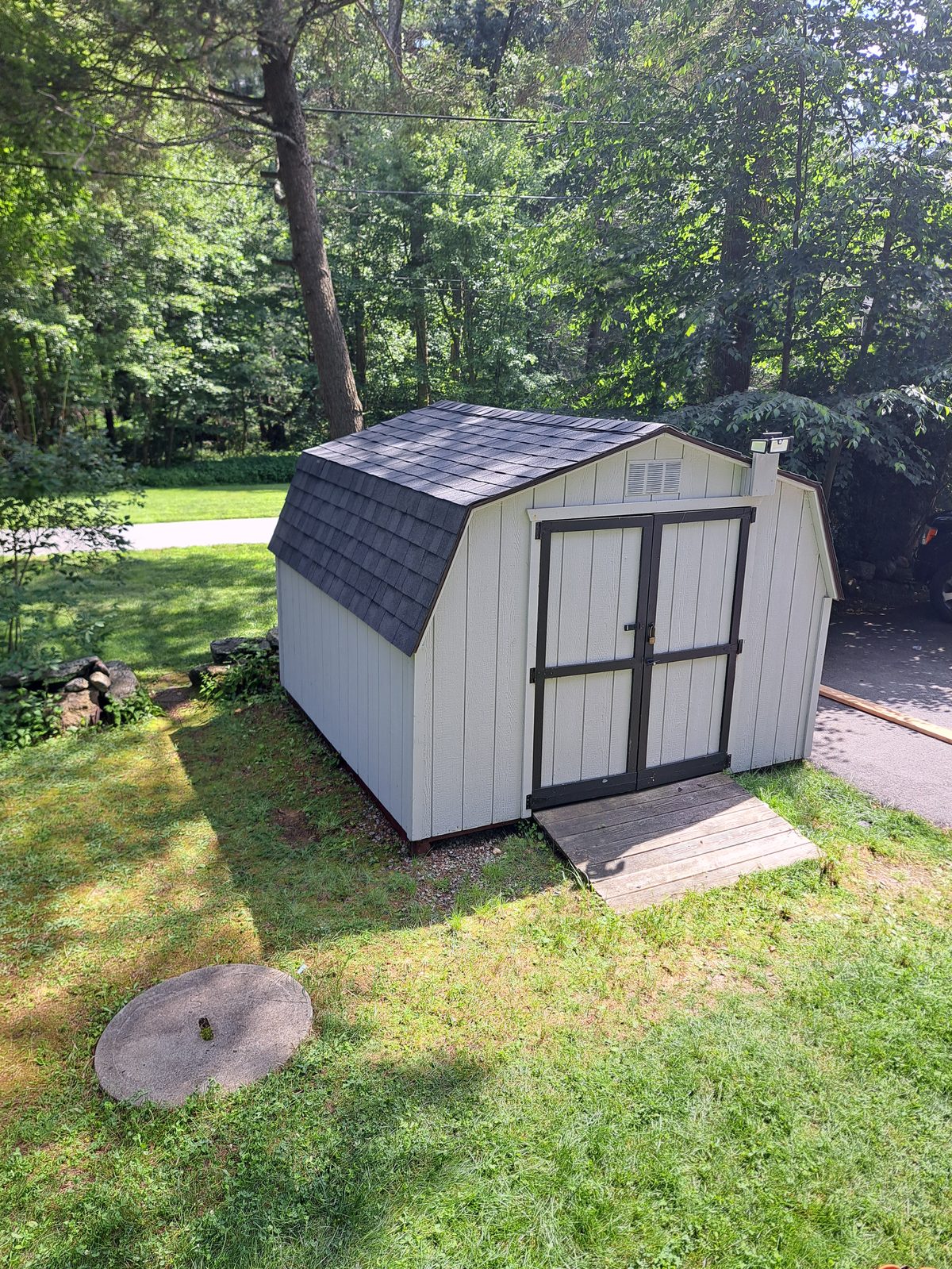 After — completed gray shed siding and roofing in Sutton, MA