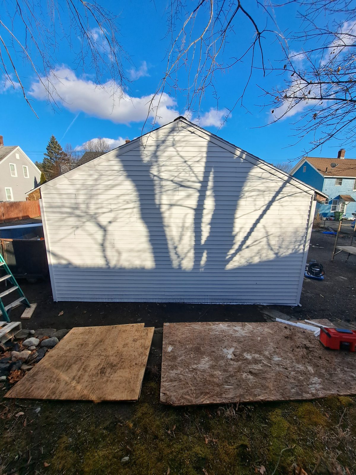 After — completed white vinyl siding on a garage gable in Sutton, MA