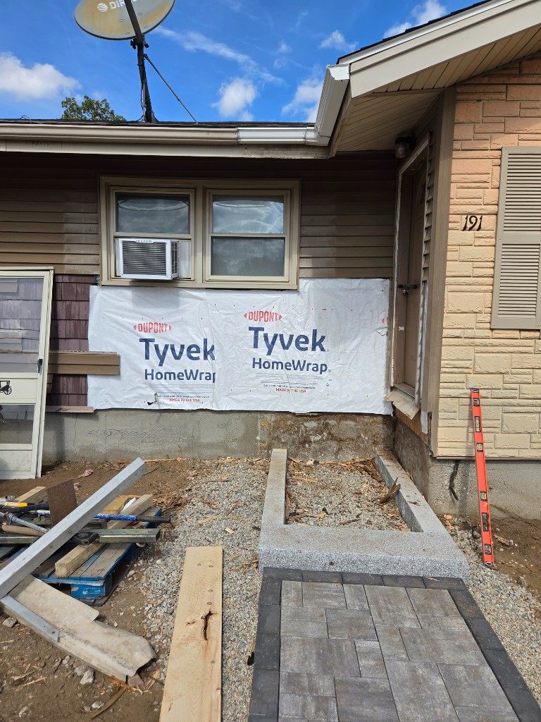 Before — house wrap on an entry wall during siding repair in Sutton, MA