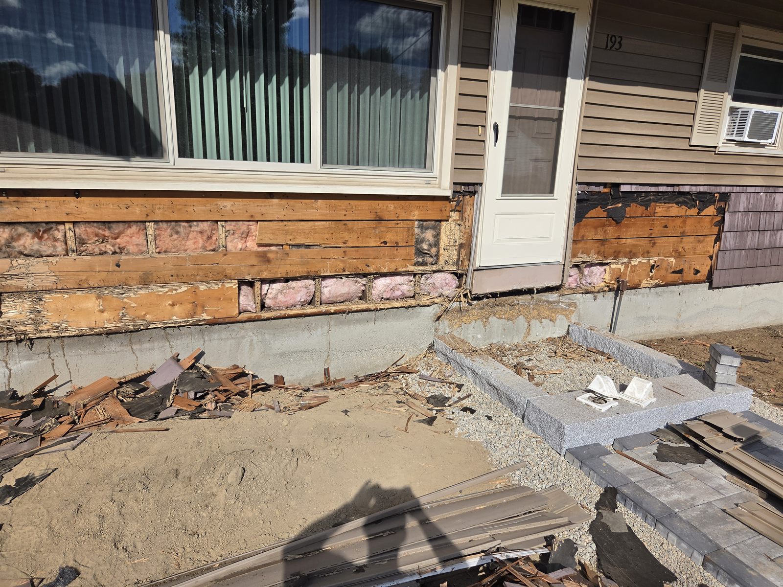 Before — exterior sheathing and insulation exposed under a window in Sutton, MA