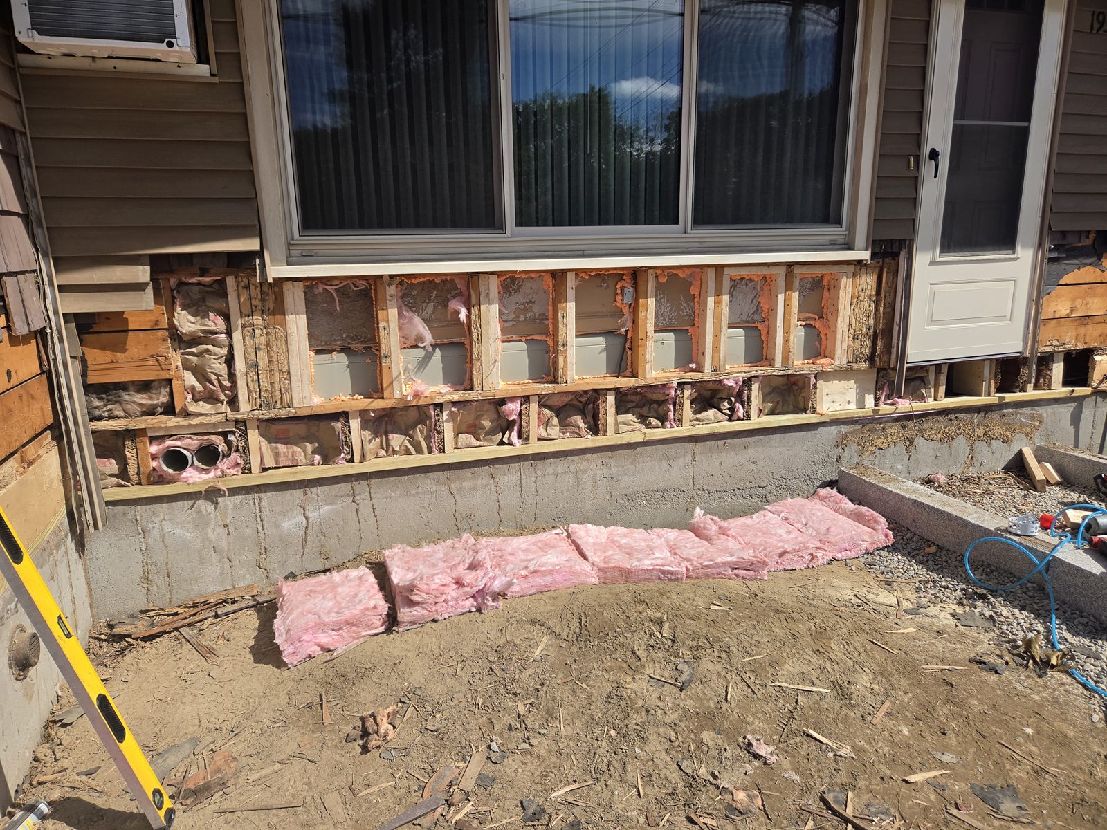 Before — stud bays and insulation during exterior wall repair in Sutton, MA