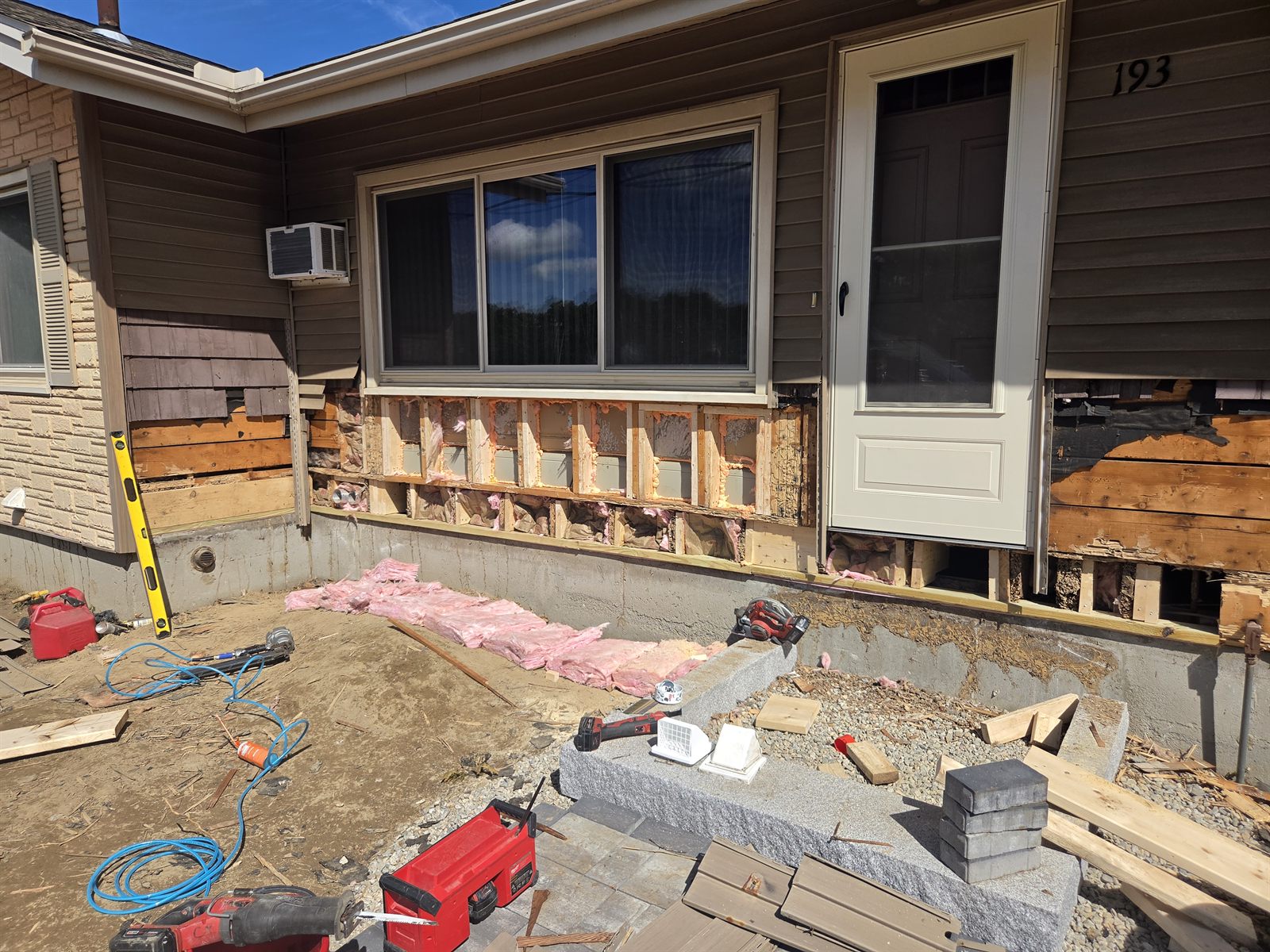 Before — wall framing under a window during siding repair in Sutton, MA